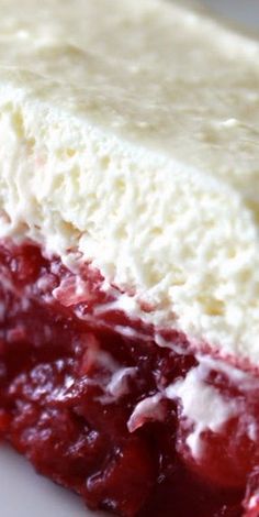 a close up of a piece of cake on a plate with whipped cream and cranberry sauce