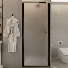 a bathroom with a glass shower door and white towels hanging on the rack next to it