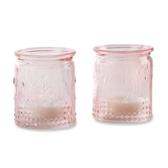 two pink glass jars sitting next to each other