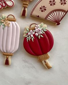 three decorated cookies sitting next to each other on top of a table with paper decorations