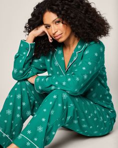 Admire wintry snowflakes without feeling any chill in the air. Flurries cover a striking emerald green flannel background, making this set a cozy hit for any holiday moment. This classic pajama set is accented with white piping and finished with logo buttons. The fabric is made from 100% of the finest quality cotton. It is yarn-dyed to prevent fade and brushed for added softness making the sleepwear feel absolutely luxurious, getting cozier after each wash. Festive Winter Cotton Sleepwear, Casual Green Christmas Sets, Green Cotton Winter Sets, Casual Green Holiday Sets, Winter Holiday Cotton Sleepwear, Green Long Sleeve Holiday Sleepwear, Holiday Green Long Sleeve Sets, Green Long Sleeve Sleepwear For Holiday, Green Cotton Christmas Sets