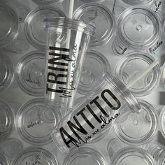 a plastic cup sitting on top of a table filled with empty cups and straws