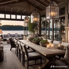 a dining room table and chairs with candles on it in front of a lake view