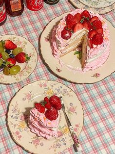 there are three plates with cake and fruit on the tablecloth, one has a slice missing from it