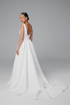 a woman in a white wedding dress looking back