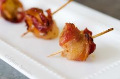 bacon wrapped in toothpicks on a white plate