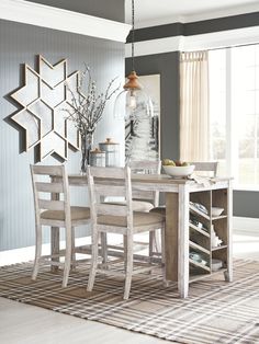 a dining room table and chairs in front of a window