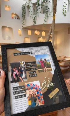 a person holding up a framed photo with pictures on it and balloons in the air