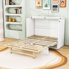 a white bed frame sitting on top of a wooden floor next to a book shelf