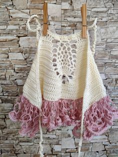 This adorable ruffles halter top, designed for toddler and baby girls. This amazing crochet top is an ideal choice for keeping little ones comfortable during scorching summer days. Crafted with care from soft baby yarn (100% microfiber), this piece ensures a gentle touch against delicate skin. The summer crop top features a convenient tie-around design for the neck and back, ensuring a secure fit and stylish look. With its breathable construction, this top becomes the perfect clothing option for kids to beat the heat in style. Please take a moment to select the appropriate size before placing your order, allowing us to provide the perfect fit for your child. Material: Crafted from 100% microfiber, the yarn used in this creation ensures both comfort and quality. Color: Available in a delica White Ruffle Halter Top For Spring, White Ruffled Halter Top For Spring, Spring White Halter Top With Ruffles, White Ruffled Halter Top For Summer, Fitted Bohemian Crop Top With Ruffles, Bohemian Pink Tops With Ruffles, Bohemian Halter Top With Crochet Trim, Spring Festival Halter Top With Crochet Trim, Bohemian Crochet Lace Halter Top For Summer