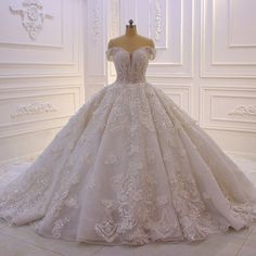 a wedding dress on display in a white room