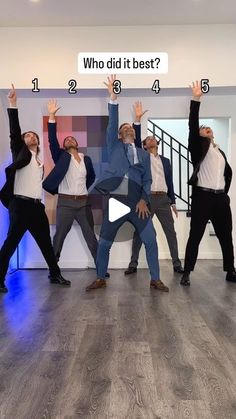 a group of men standing on top of a wooden floor in front of a white wall