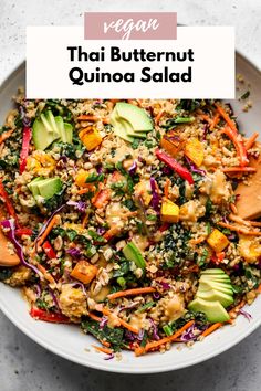 a white bowl filled with quinoa salad topped with avocado and carrots