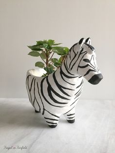 a ceramic zebra planter with a potted plant in it