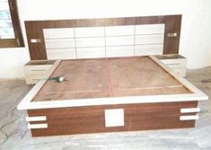 a bed frame with drawers on each side and a headboard made out of wood