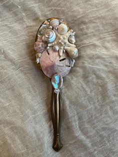 One of a kind upcycled vanity hair brush made with seashells, diamonds, pearls, coral, miscellaneous jewelry, starfish, abalone, sand dollar, and other oceanic materials ✨🫧  Approximately 3 inches wide by 1p inches long, handle with care it's delicate 🐚 Mermaid Hair Brush, Pearl Core Aesthetic, Mermaid Core Room Decor, Seashell Jewelry Holder, Mermaid Trinkets, Upcycled Vanity, Brush Aesthetic, Mermaid Items, Sand Jar