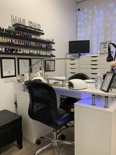 an office desk with lots of items on top of it and a chair in front of the desk