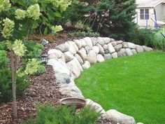 a stone wall in the middle of a yard