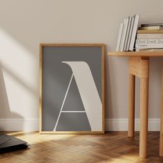 a framed poster sitting on top of a hard wood floor next to a laptop computer