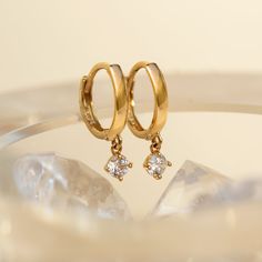 This 14K Gold Small Hoop earrings feature a tiny dangling Crystal. Solid Gold makes these pair tarnish-free! Smaller in size-Great for smaller lobes or second piercings. 14K Gold Moissanite Crystals Hypoallergenic, lead and nickel free Thickness 1.8mm Diameter Sizes: Inside 8.2mm Stone Diameter: 3mm Click Snap closure #ES055-G Gold Small Hoop Earrings, Designer Jewelery, Simple Gold Earrings, Gold Jewels Design, Nose Earrings, Second Piercing, Bead Embroidery Patterns, Minimal Earrings, Small Hoop Earrings