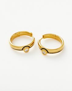 Enamel & Stone Byline Medium Hoop Earrings | 18ct Gold Plated Vermeil/Cubic Zirconia 18ct Gold Plated/Cubic Zirconia. These Medium-Sized Hoops Feature Hand-Painted Black Enamel Line Detailing and Rounded Cubic Zirconia Stones. Have a Matching Moment with the Enamel & Stone Byline Stacking Band Ring. Metal: 18Ct Recycled Gold Plating on Brass Stone: White Cubic Zirconia Materials: Black Enamel Dimensions: 20mm X 4. 2mm Weight: 7. 9g Product Code: Gu-G-E10-Cz Gold Hoop Jewelry With Channel Set, Luxury Gold Earrings With Bezel Setting, 14k Gold Channel Set Gold Hoop Earrings, Gold Channel Set Hoop Earrings, 14k Gold Bezel Set Huggie Earrings For Anniversary, Gold Polished Round Diamond Earrings, Fine Jewelry Yellow Gold Huggie Earrings With Bezel Setting, Fine Jewelry Bezel Setting Hoop Earrings For Formal Occasions, Yellow Gold Bezel Setting Huggie Earrings Fine Jewelry