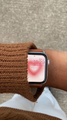 an apple watch on someone's arm with the screen partially covered by a brown sweater