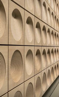 the wall is made out of wood and has circular holes on each side that are lined with circles