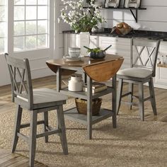 a dining room table and chairs in front of a window