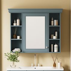 a bathroom vanity with blue cabinets and white counter top next to a wall mounted mirror