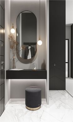 a bathroom with a round mirror and black counter top next to a gray stool in front of a white wall