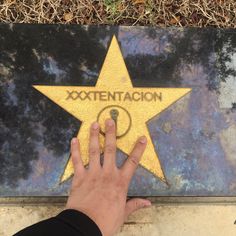 a person's hand touching the star on the hollywood walk of fame