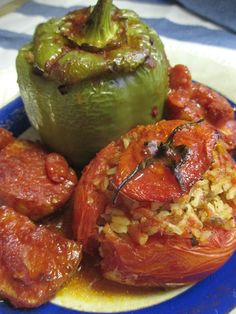 a blue plate topped with tomatoes and rice next to a green pepper on top of it