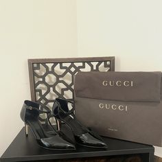 Crafted From Black Patent Leather, A T-Strap Detail On The Front Enhances This Classic Silhouette. The Heel Is 3 Inches In Height. Gently Worn With Some Scuff Marks. The Original Box, Dust Bag, And Replacement Heel Tips Are Included. Gucci Fitted Evening Heels, Chic Gucci Heels For Office, Gucci Ankle Strap Heels For Office, Gucci Formal Heels With Heel Strap, Gucci Patent Leather Heels With Heel Strap, Gucci Elegant Pointed Toe Heels, Elegant Gucci Pointed Toe Heels, Chic Gucci Formal Heels, Gucci Patent Leather Heels For Evening