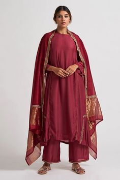 Maroon asymmetric hem A line kurta in hand embroidered dabka work. Paired cotton silk palazzo with floral embroidered hem and sheer chanderi dupatta broad gold hem.
Component: 3
Pattern: Hand embroidered
Type Of Work: Thread work, Gota patti
Neckline: High neck
Sleeve Type: Three quarter
Fabric: Cotton silk, Chanderi
Color: Maroon
Other Details: 
Piping detail
Side pocket
Occasion: Sangeet ,Work - Aza Fashions Rave Party Outfit, Gharara Designs, Kurta Palazzo Set, Straight Suit, Deep Maroon, Aesthetic Dress, A Line Kurta, Palazzo Set, Indian Fashion Designers