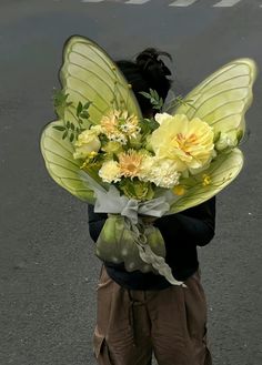 a woman holding a bouquet of yellow flowers