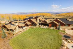 this is an aerial view of a home in the mountains with trees and grass around it