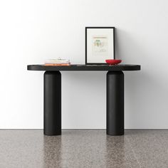 a black table with two red bowls on it and a white wall in the background