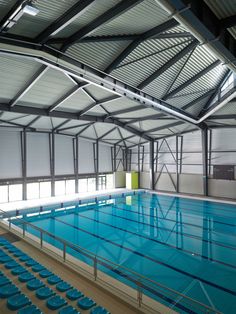 an indoor swimming pool with blue seats