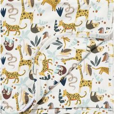 a blanket with giraffes and other animals printed on the front, along with a white background