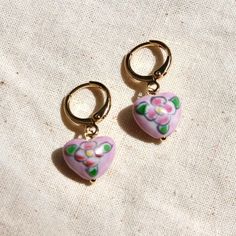 These earrings feature the prettiest hand painted vintage glass heart beads that were made in the Czech Republic in the 1960s attached to 14k gold plated hoops. Bead size: 9x12mm  Hoops: 12mm Please note there may be slight variances in the shape and design on the beads due to the hand painted, vintage nature. Hand Painted Beads, Pretty Hands, Floral Heart, Glass Heart, Heart Beads, Bead Earrings, 2024 Collection, Jewelry Earrings Hoops, Bracelets And Charms