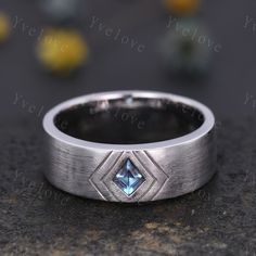 a wedding band with a blue diamond in the center