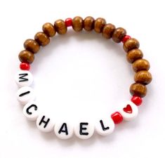 a bracelet with the word michael written in white, red and black letters on it