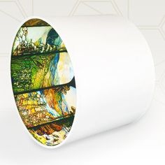 a white toilet paper holder with an artistic painting on the side and bottom part of it