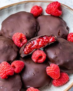 chocolate covered raspberries are arranged on a plate