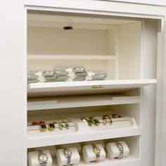 a white shelf with many different types of jewelry