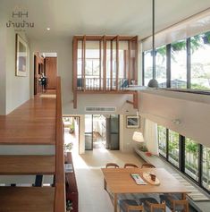 an aerial view of a living room and dining area from the second floor, looking down