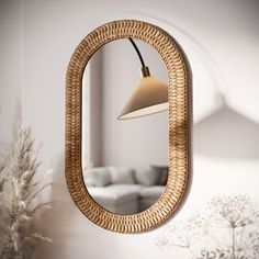 a mirror hanging on the wall next to a plant