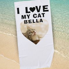 a beach towel with a photo of a cat in the shape of a heart on it