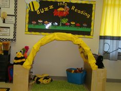 a child's play area with stuffed animals on the floor and a sign that says buzz into reading