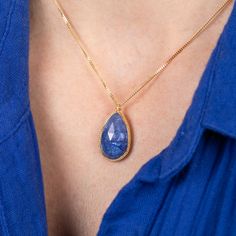 This magnificent Tanzanite is a perfect statement necklace with its bold navy blue color and striking faceted surface. This captivating gemstone is set in a handmade gold setting accented with braided gold. It’s strung on an 18k yellow gold chain. One of a kind. Technical Details Metal: 18k yellow goldTanzanite: 12.77 cts. Pendant Size (not including bail): 21mm x 14mmChain: can be worn at 16" and 18"Closure: lobster claspHandmade in New YorkStyle # N-3164-TA Yellow Gold Briolette Sapphire Necklaces, Gold Tanzanite Pendant Necklace, Gold Tanzanite Teardrop Jewelry, Tanzanite Briolette Necklace Gift, Gold Necklaces With Sapphire And Gemstone Accents, Gold Teardrop Sapphire Necklace, Briolette Tanzanite Necklace For Gift, Gold Tanzanite Jewelry With Faceted Design, Gold Necklaces With Sapphire Briolette